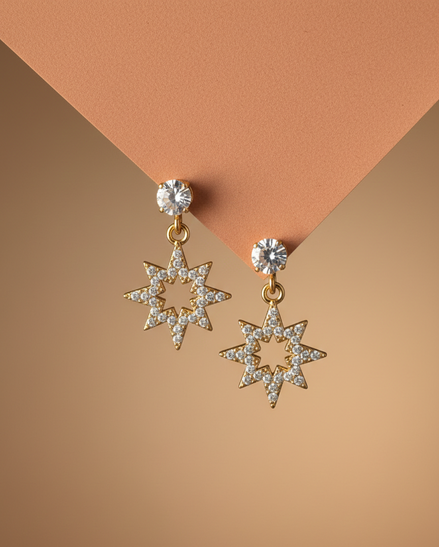 Star-shaped earrings with clear stones on a two-tone brown background